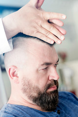 Obraz premium Barber makes styling a mohawk for an adult man.