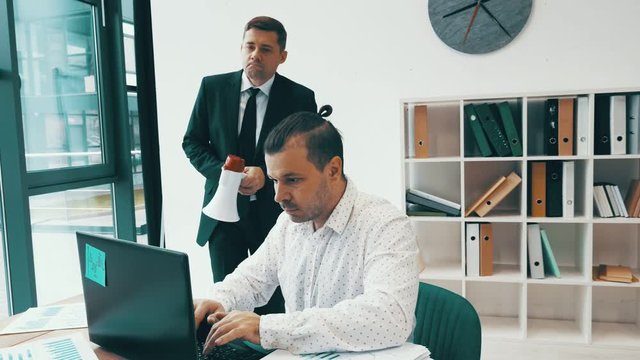 Evil angry boss yells at an employee in the office. The manager makes man work faster. Conflicts and bullying at work. Fun video.