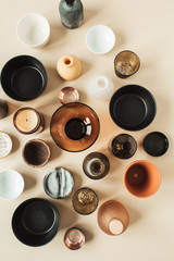 Many bowls, containers, saucers on pastel beige background. Flat lay, top view.