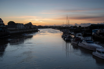 Fototapeta premium Morning Sunrise The River Arun Littlehampton with yachts and boats in the foreground, a calm and peaceful scene.