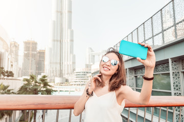 Happy girl traveler and blogger takes selfie photo in Dubai, United Arab Emirates