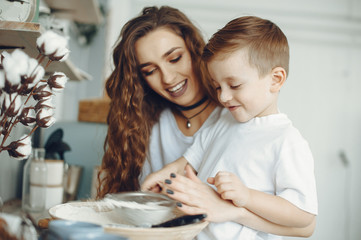 Fototapeta na wymiar Young and beautiful mom with son. Family is preparing food at home. Little boy in a kitchen