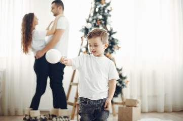 Family in a room. Little boy near christmas decoration. Mother with father with son