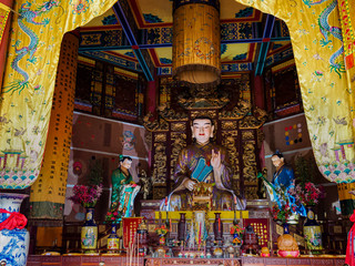 Elaborately carved and decorated statue of Buddha at a Taoist temple in Hainan, China