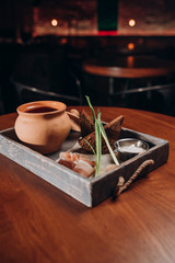 borscht in a pot with bacon, green onions and croutons