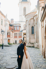 Fototapeta na wymiar Bride and groom walking through the old town