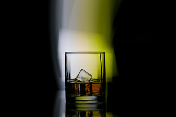 glass of whiskey in spotlight background