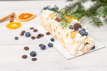 Christmas meringue roll with lemon, blueberry and chocolate