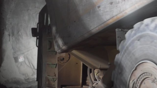 Slow motion of haul truck driving down decline in underground gold mine