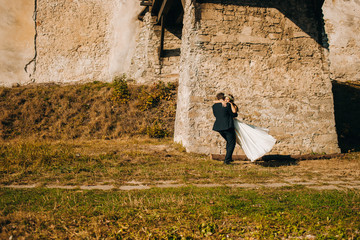 Happy newlyweds are walking under a big bridge
