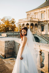 Fototapeta premium Pretty bride stands on the balcony of an old castle
