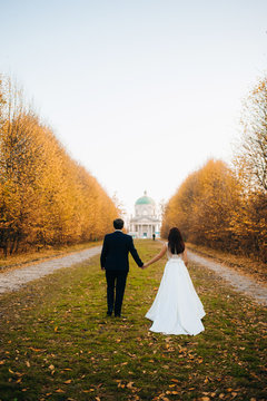 Newlyweds  walking near vintage colorful, renaissance palaces. Photo shoot near Medieval Castle