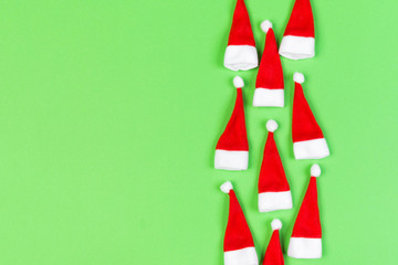Top view od stylish red Santa hats on colorful background. Merry Christmas concept with copy space