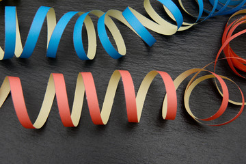 colorful streamer lying on black shale, whether new year's eve or carnival, it is always the right...