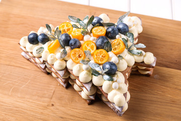 Delicious pie in christmas tree decoration frame, top view. Rustic style. Traditional homemade christmas cake on wooden board.