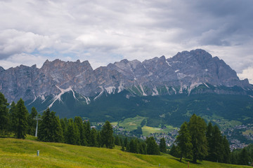 Obraz premium View of Cortina D'Ampezzo at distance with Monte Cristallo mountains on background, tourism travel concept, copy space, day. Italy, South Tyrol.
