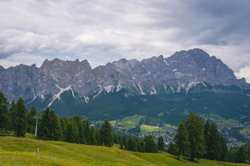 View of Cortina D'Ampezzo at distance with Monte Cristallo mountains on background, tourism travel concept, copy space, day. Italy, South Tyrol.