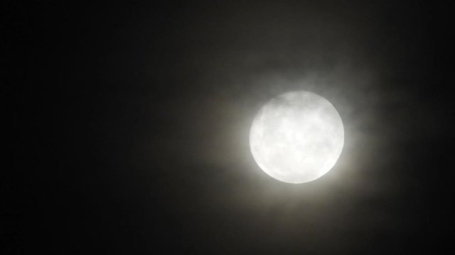 Haunted full moon with eerie dark clouds moving past in the foreground, perfect for halloween or scary video transitions.