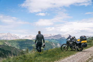 Fototapeta na wymiar Motorcycle rider enjoy the momment. Touring adventure motorbike on the top of mountain, enduro, off road, beautiful view, danger road, freedom, extreme vacation. Passo Pordoi, Italy