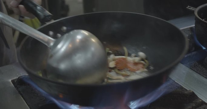 Cooking thai food fried vegetable in a wok at a restaurant in MBK Center in Bangkok - Swing Wok - Slow motion - Close up