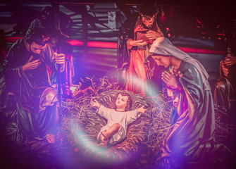 Plakat The statue of Mary Joseph and Jesus, Jesus' birthday baby is a statue of Maria and Joseph and Jesus, a newborn baby. There is a beautiful aura light on the hay. Christmas nativity scene