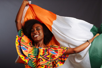 Happy african woman in national clothes smiling and posing with a flag Ivory Coast, C te d'Ivoire...