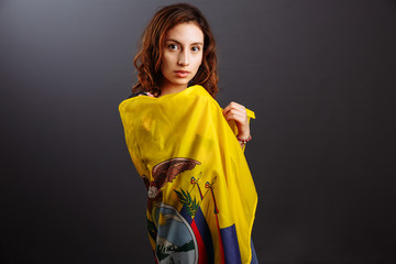 Happy Ecuadorian woman smiling and posing with a flag - isolated over a gray background