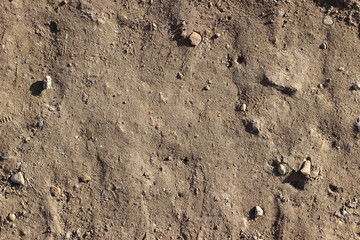Dirt road surface with stones, dry soil, close up, top down