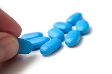 Closeup of blue pils in hand on white background