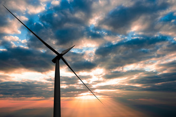 Silhouette of wind turbines at sun rises in morning time, alternative energy concept.
