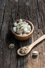 Pistachio nut in wooden bowl on rusty wood table background