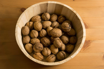 Basket with tasty walnuts on wooden background