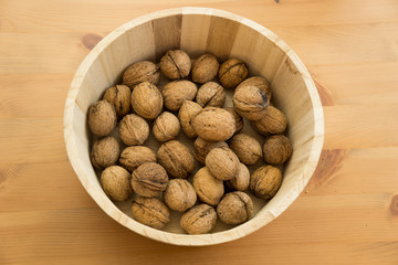 Basket with tasty walnuts on wooden background