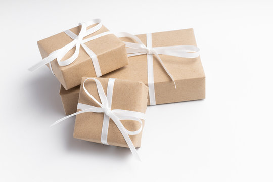 Brown gift box tied with white ribbon on clear background