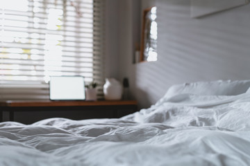 laptop with copy space empty screen and bed with white sheets