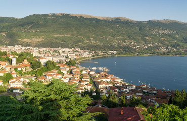Obraz premium Ohrid and Ohrid Lake on a sunny summer day, view from above from castle hill, mountains and the blue sky in background. Ohrid and Lake Ohrid are Cultural and Natural World Heritage Sites by UNESCO.