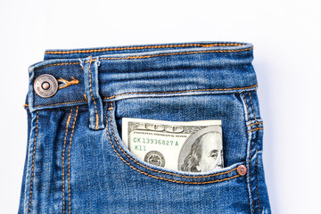 American dollar banknote in a pocket of blue jeans, franklin watching from pocket copy space