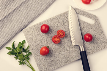 Fresh tomatoes on a cutting kitchen board made of artificial stone