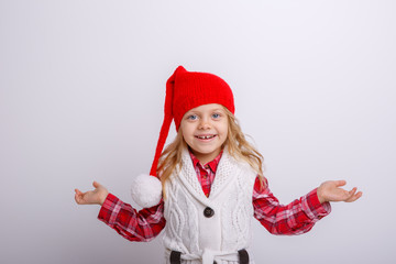 cute happy little girl in santa claus hat. Santa's assistant smiles  on a white background