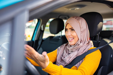 Muslim woman driving and yelling. Negative human emotions face expression. Side profile angry female driver. Angry woman driving a car. The girl with an expression of displeasure