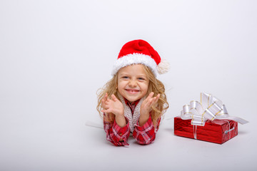 little girl in Santa hat lying on white background isolated on white background