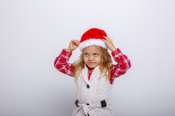 cute happy little girl in santa claus hat. Santa's assistant smiles on a white background