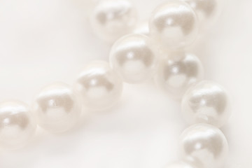 Necklace with shining white pearl criss cross isolated background macro