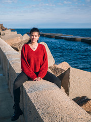 latina girl near the sea sit on the rocks
