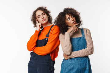 Portrait of perplexed multinational women looking upward and downward