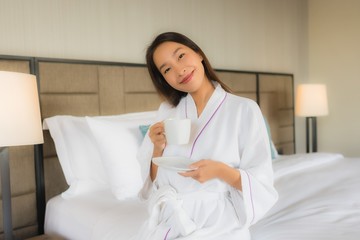 Portrait beautiful young asian women with coffee cup on bed