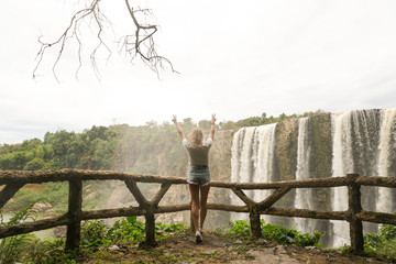 The girl standing near the waterfall