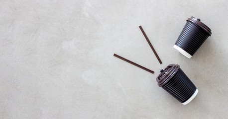 black paper cup of coffee on cement floor background