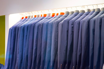 A row of men's jackets on a hanger in a clothing store.