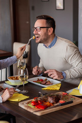 Couple tasting each others food in restaurant